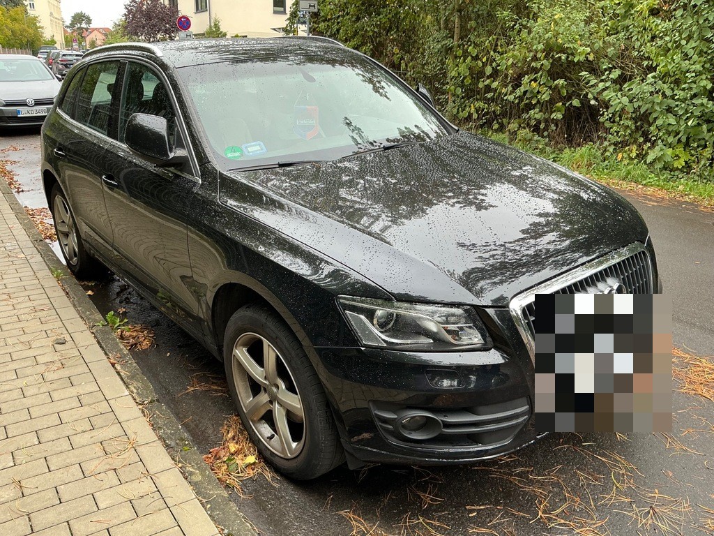 Frontansicht schräg links, schwarzes SUV am Straßenrand geparkt, keine sichtbaren Schäden
