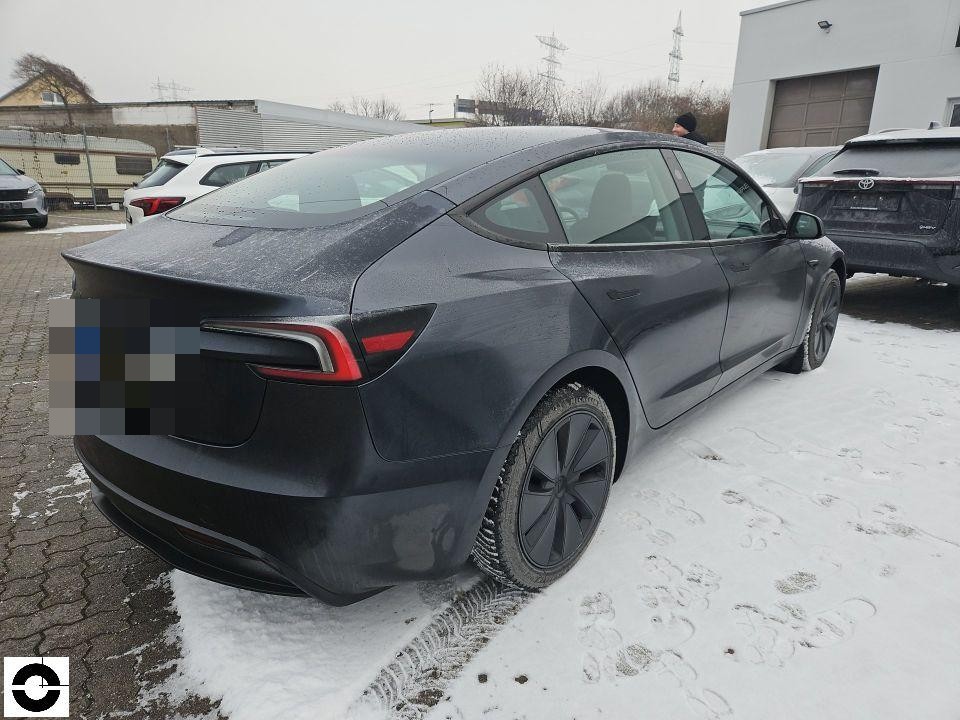 Heckansicht schräg rechts, dunkelgraues Fahrzeug auf Schneefläche, keine sichtbaren Schäden