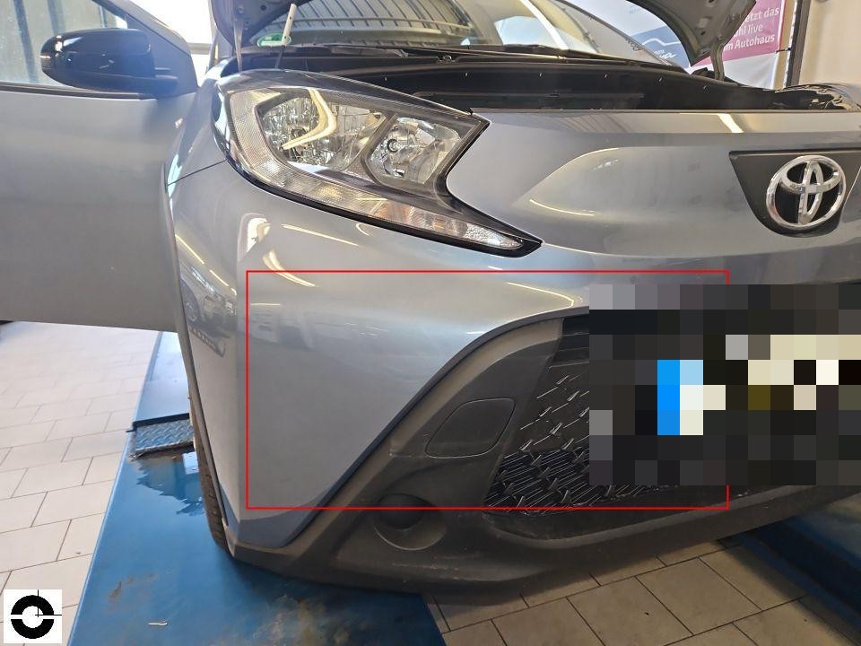 Frontansicht, Stoßfänger vorne links mit roter Markierung, Motorhaube geöffnet, Werkstattumgebung