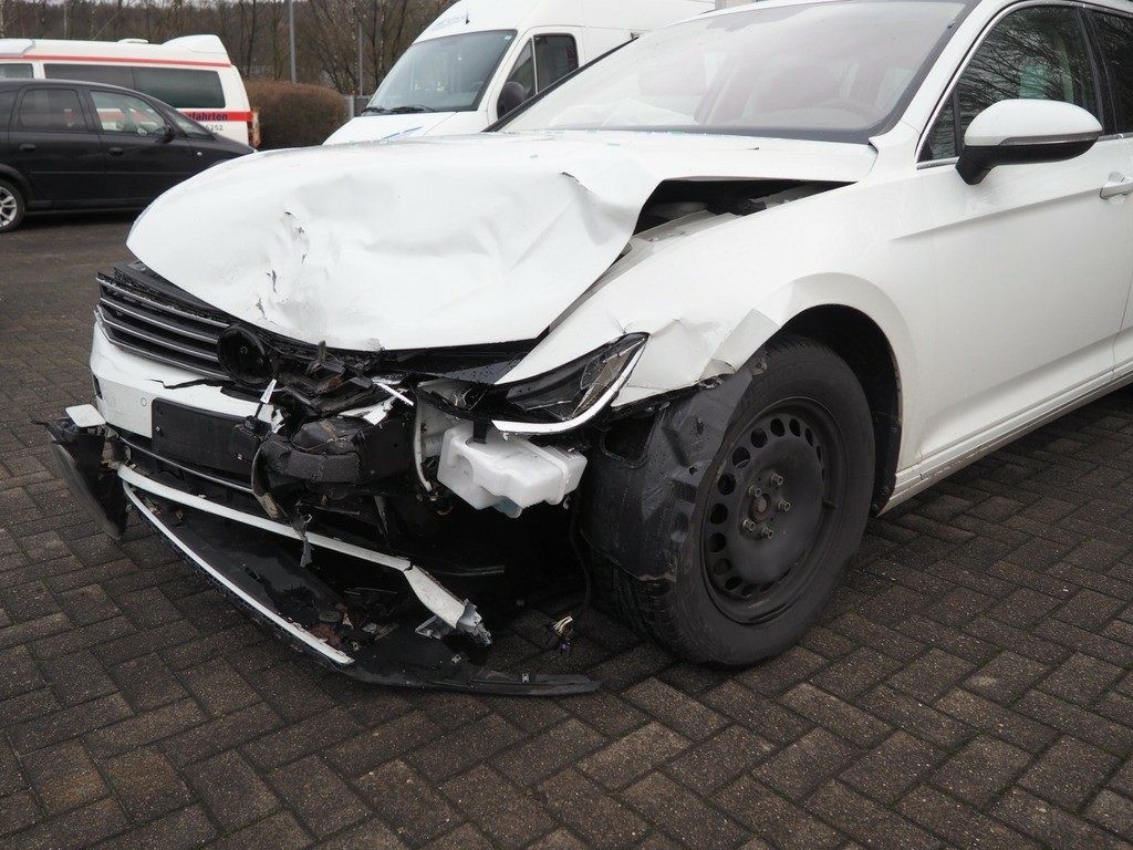 Frontansicht mit schwerem Unfallschaden, Motorhaube stark verformt, Stoßfänger abgerissen, linker Kotflügel beschädigt