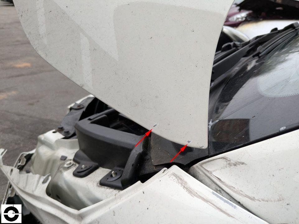 Detailaufnahme vorderer Kotflügel rechts mit Spaltmaß-Abweichung zur Motorhaube, rote Pfeile markieren Schaden