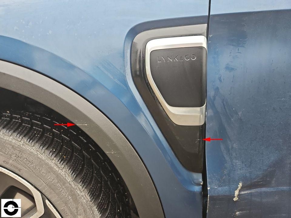 Linker vorderer Kotflügel mit Kratzern und Lackabplatzung, Lynk & Co Emblem sichtbar