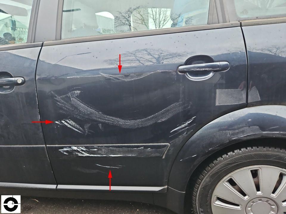 Hintere linke Tür mit Kratzern und Dellen, rote Markierungspfeile zeigen Schadenstellen